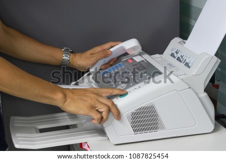 hand man are using a fax machine in the office. Business concept 