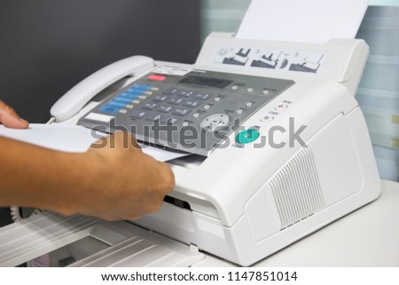 hand man are using a fax machine in the office. Business concept 