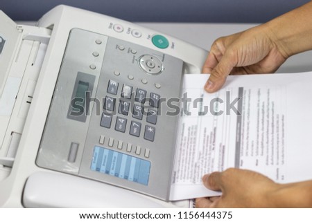 Hand man are using a fax machine in the office. Business concept 