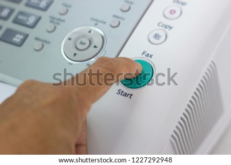 Hand man are using a fax machine and finger pressing start button