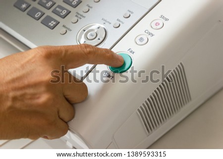 Hand man are using a fax machine in the office Business concept 
