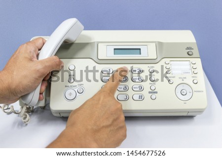 hand man are using a fax machine in the office Business concept 