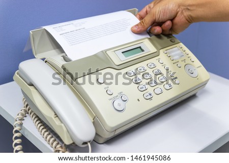 hand man are using a fax machine in the office, equipment for data transmission.