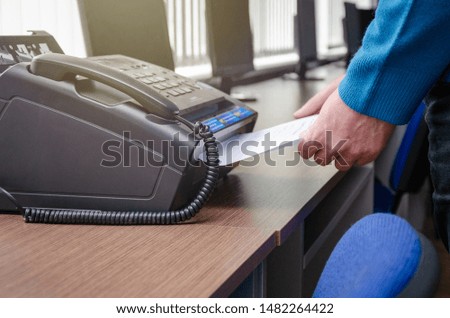 hand man are using a fax machine in the office Business concept