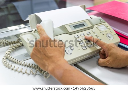 hand man are using a fax machine in the office, equipment for data transmission.