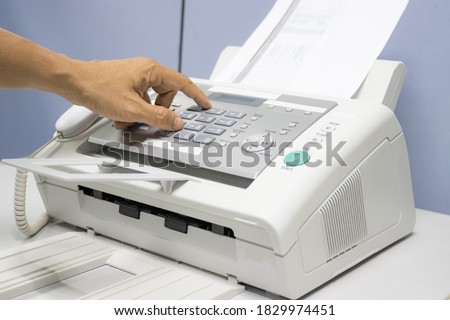 hand man are using a fax machine in the office, equipment for data transmission.