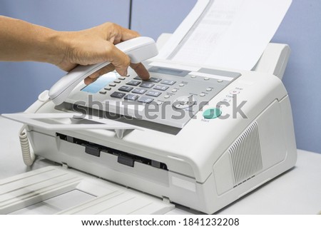 hand man are using a fax machine in the office, equipment for data transmission.