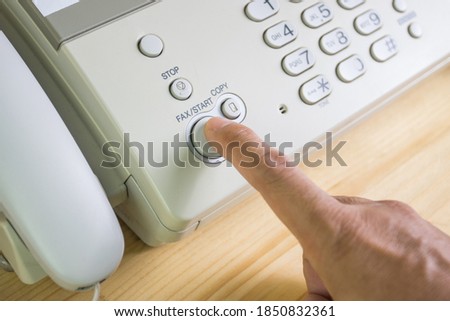 hand man are using a fax machine in the office, equipment for data transmission.
