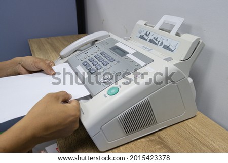 hand man are using a fax machine in the office, equipment for data transmission.