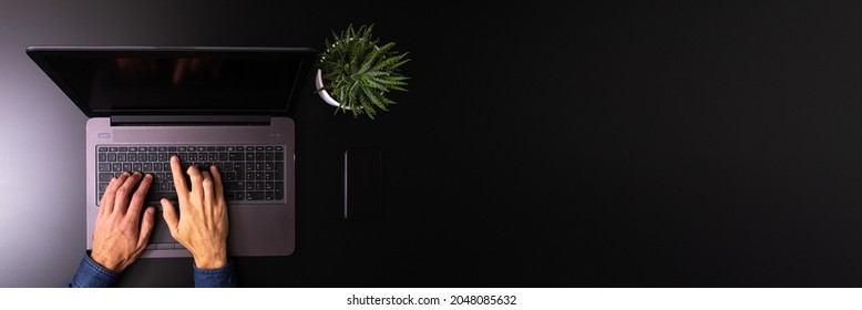 Hand of a man using laptop computer working overtime in the office late at night