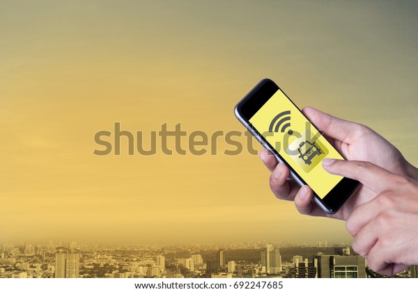 Hand of man\
using smartphone call taxi by application smartphone and wifi\
networking with cityscape\
background.