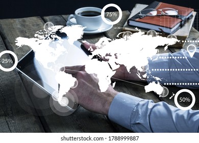 Hand of a man using tablet computer on office table with business infographics