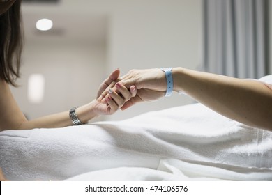 Hand Of Man And Woman Couple In Hospital And Patient Bed With Hospital Tag On Wrist With Love Hope And Care