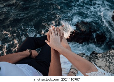 Hand of a man and a woman with wedding rings on a rock - Powered by Shutterstock