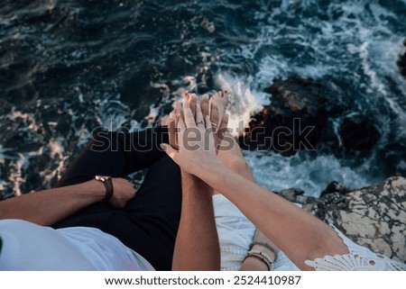 Hand of a man and a woman with wedding rings on a rock