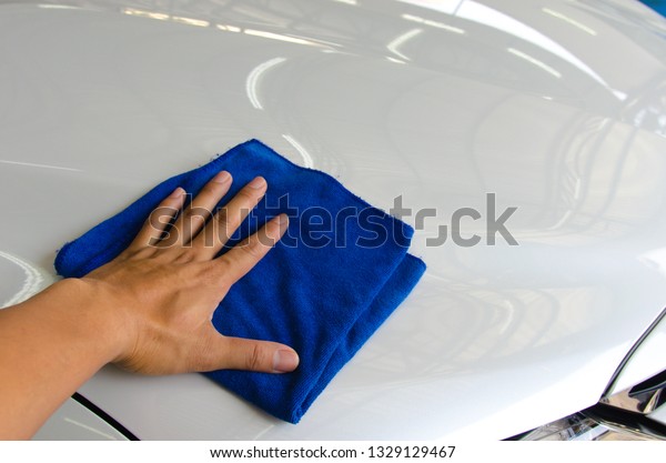 Hand man
worker use clean blue cloth to wipe the
car