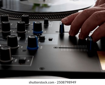 A hand manipulating a deejay mixer.