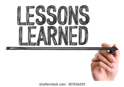 Hand with marker writing the word Lessons Learned