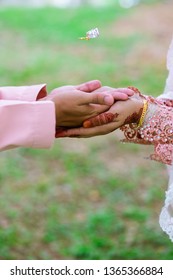 A Hand Of Married Couple With Wedding Ring Floating On Air. Selective Focus 