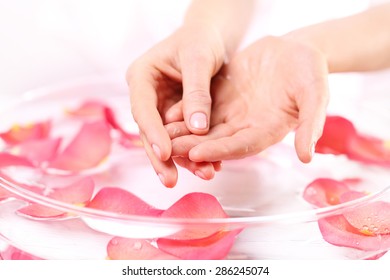 Hand Massage, Acupressure.  Beauty Ritual For Hands. Care Treatment Of Hands And Nails Woman Hands Over The Bowl With Rose Petals 