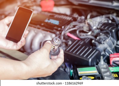 Hand Mechanic With Car Thermostat And Use Smart Phone For Basic Checking A Engine Of Car Maintenance And Service Check In Garage