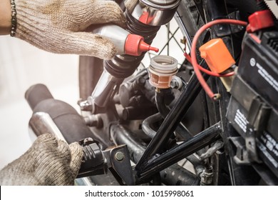 hand of Mechanic Check and Add Brake fluid to motorcycle , selective focus . auto mechanic uses to check and Maintenance motorcycle brake disc system - Powered by Shutterstock