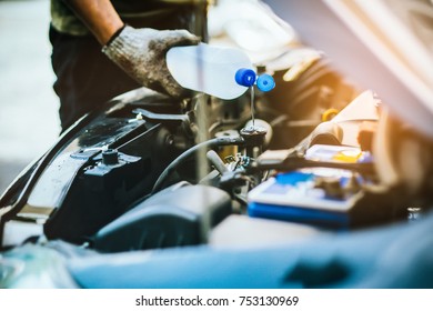 hand of Mechanic Check water in Car radiator and Add water to car radiator, selective focus - Shutterstock ID 753130969