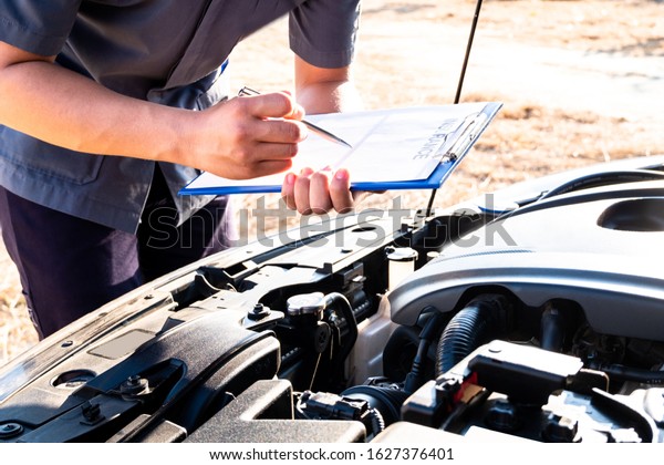 The hand of the mechanic is checking the\
order of the engine and note the\
information.