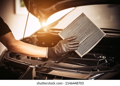 Hand Of Mechanic Holding Car Air Filter Old And Dirty With Dust Stains For Checking Cleaning And Replacing New Filter. Concept Of Car Care Service Maintenance.