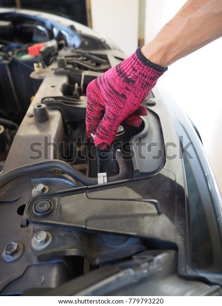 Hand of mechanic man with the engine service or\
repair in an automotive\
workshop;