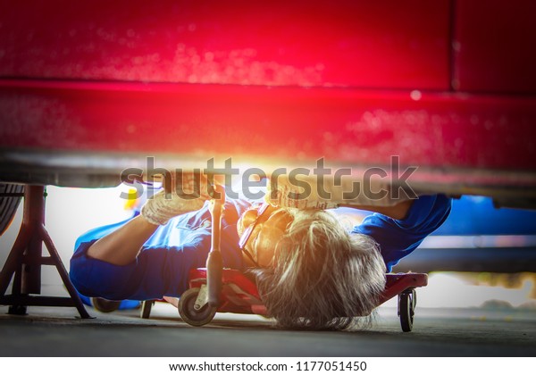 Hand mechanic in repairing car,Change the Oil and\
Undercarriage Repair
