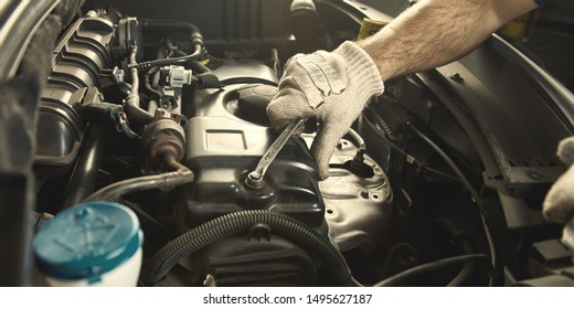 Hand Of Mechatronics Engineer At Engine Repairing Car In A Car Workshop