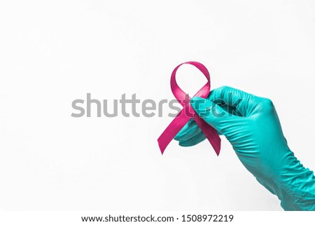 hand in medical glove holds tape in hands, an international day of protecting people from cancer, healthcare and medicine concept 