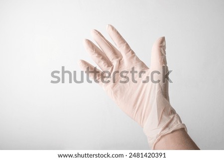 Hand in medical glove on white background. Elastic disposable gloves. Latex sterile protective glove close up. Females doctor. Hygiene, health care. Beauty salon. Covid-19. High quality photo.