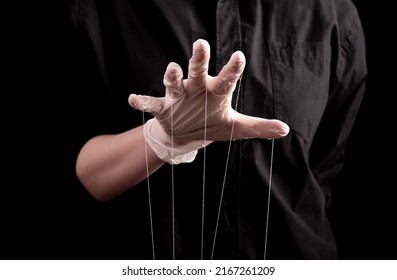Hand in medical glove with strings on fingers. Deception in medicine and pharmacy, conspiracy theory, health care fraud, spreading false information about diseases, medication. High quality photo