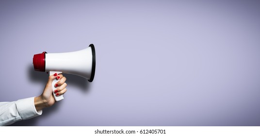 hand with a megaphone in front of an empty background - Shutterstock ID 612405701