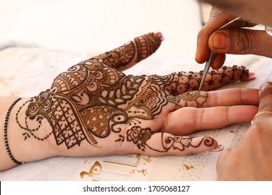 Hand mehndi designs are being prepared and ready for the function