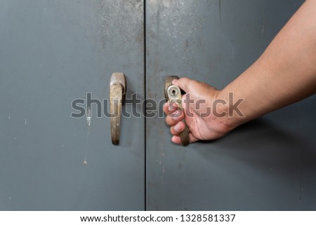 Hand of men is opening old and rusty steel cabinet