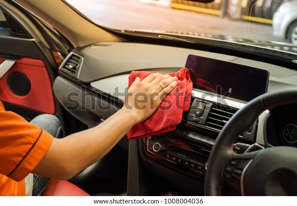 Hand with microfiber cloth cleaning car interior,
Fucus  On Hand