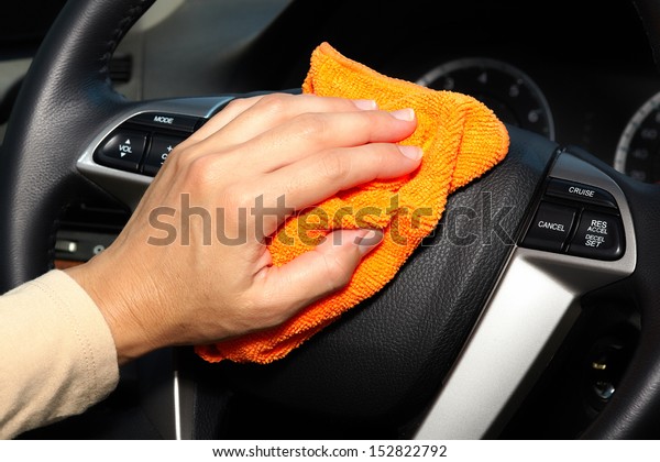 Hand with microfiber
cloth cleaning car.