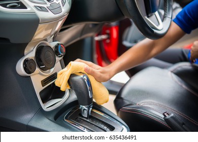 Hand with microfiber cloth cleaningcar interior close up