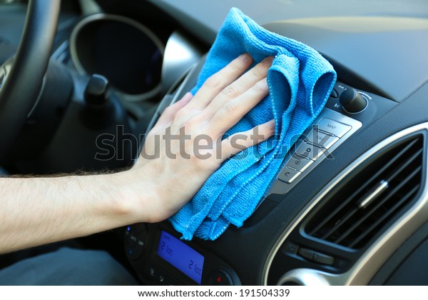 Hand with microfiber\
cloth polishing car