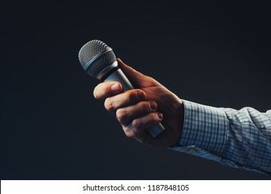Hand with microphone doing an interview for the media, selective focus