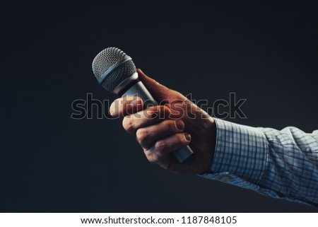 Hand with microphone doing an interview for the media, selective focus