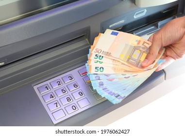 Hand With A Lot Of Money Just Withdrawn From The ATM Machine And The Numbers On The Numeric Keypad To Make The PIN Code