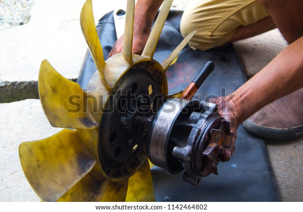 Hand of\
motorists repair Radiator fan. Car radiator fan repair Because the\
radiator fan is damaged and cannot be\
used.