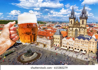 Hand with a mug of beer on the background of the Old Town Square in Prague