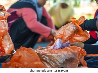 Hand of muslimah packaging the meat with shallow depth of field (DOF)