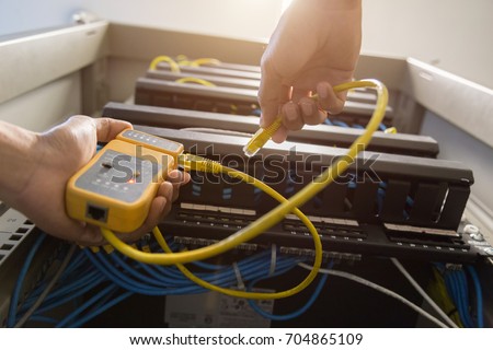 hand with network cables connected to servers in a datacenter,equipment. Tester cable lan in the hands.