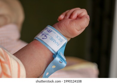 Hand Of Newborn Baby With A Name Band On His Wrist